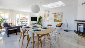 Un salon moderne comprenant un coin repas, un canapé, un téléviseur et une cheminée.