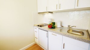 A kitchen with white cabinets, a stainless steel sink, and a granite countertop. - Modern apartment in Westerland with balcony, parking and WiFi (Westerland)