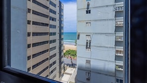 Vista de dos edificios altos con una playa y el océano al fondo.