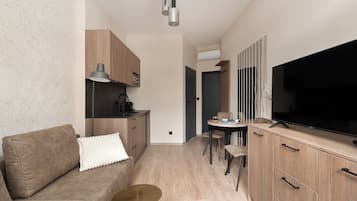 Suite estudio Deluxe, balcón | Zona de estar | Una televisión de pantalla plana
