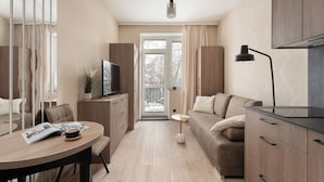 Une pièce moderne et bien éclairée, comprenant une table à manger, un canapé et des meubles de rangement.