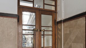 Une porte en bois avec des panneaux de verre et une poignée en laiton.