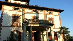 A large, two-story building with a symmetrical facade, a central entrance with a portico supported by columns, and a balcony above the entrance. - hotel Villa Conte Riccardi (Rocca D'Arazzo)