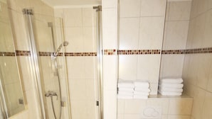 A bathroom with a glass-enclosed shower, a sink, a toilet, and a towel rack. - Cozy vacation apartment on the 1st floor in a quiet location in Wenningstedt (Wenningstedt)