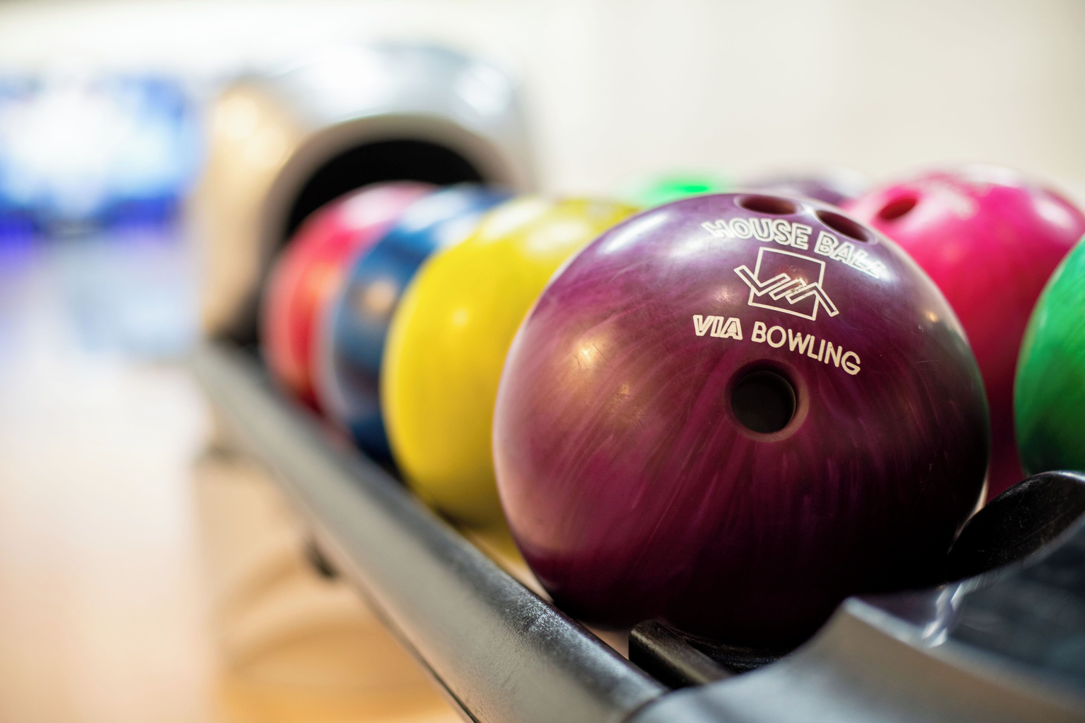 Une rangée de boules de bowling sur un présentoir.
