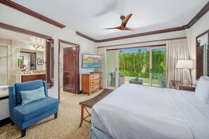 Ein Hotelzimmer mit Bett, Schreibtisch, Stuhl, Kommode und Fernseher.