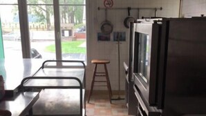 Una cocina con una estufa grande, un lavabo y un ventanal con vistas a un aparcamiento.