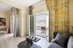 Uma sala de estar moderna com um sofá, mesa de centro e porta de vidro que dá para uma varanda.