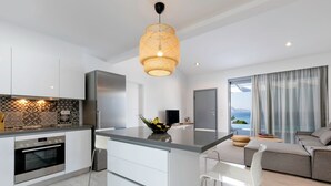 Une cuisine moderne dotée d’un îlot central, d’appareils électroménagers en acier inoxydable et d’un revêtement mural décoratif.