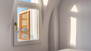 Ein Schlafzimmer mit einem Bett, einem Fenster und einem Apfel auf dem Bett.
