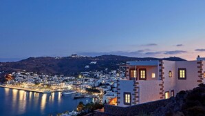 A coastal town at dusk with white buildings, a marina, and boats.