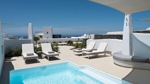 A rooftop pool area with white lounge chairs and a clear view of the ocean. - Lavish Santorini Suite | Sunset Embrace Suite | Executive Two Bedroom Suite. (Santorini)