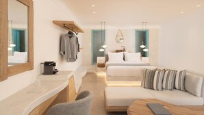 A modern hotel room with a large mirror, a wooden shelf, a desk with a lamp, a sofa with patterned cushions, and a bed with a headboard. - Endearing Santorini Suite | Aegean Serenity Suite | Junior Suite with Private. (Santorini)