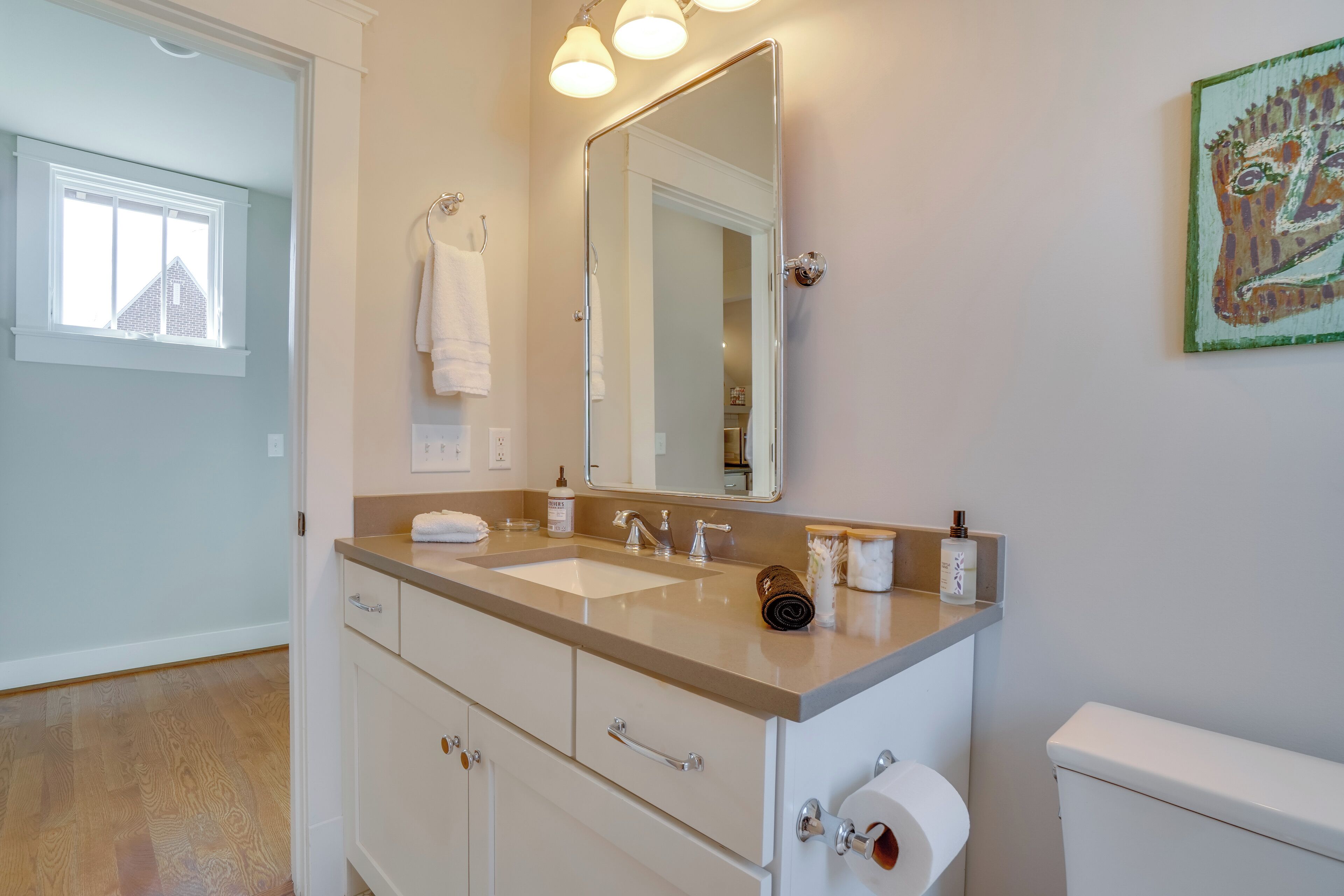 A bathroom with a double sink, a large mirror, and a toilet.