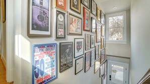 Eine Wand mit verschiedenen gerahmten Gegenständen, darunter Zertifikate und Auszeichnungen, sowie eine Treppe, die zu einer anderen Etage führt.