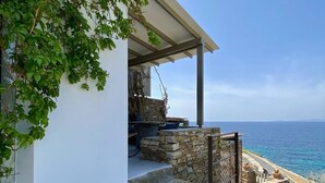 A stone staircase leading to a covered outdoor area with a view of the sea. - Thrilling Tinos See Front Studio | Zoi Studio | Breathtaking Sea Views |. (Tinos)