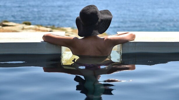 A person relaxing by a pool with a view of the ocean. - Thrilling Tinos See Front Studio | Zoi Studio | Breathtaking Sea Views |. (Tinos)