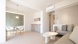 Una sala de estar moderna con un sofá, una mesa redonda de centro y un comedor con sillas y una mesa.