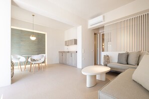 Un salon moderne avec un canapé, une table basse ronde et un coin repas comprenant des chaises et une table.