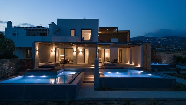 Una casa moderna de dos pisos con piscina y zona de estar al aire libre.