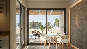 Un interior moderno con un puerta de cristal que da a un balcón con vistas a la playa.