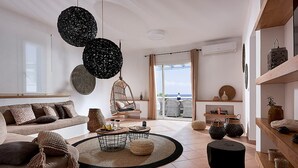 Uma sala de estar moderna com sofá, mesa de centro e luminárias pendentes.