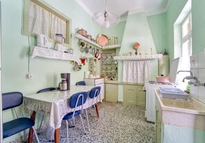 A compact kitchen with a dining table, chairs, and a sink.