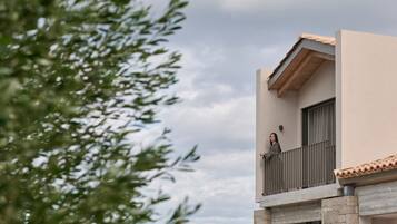 A modern building with a balcony and a stone base.