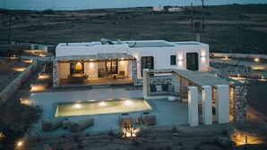Une villa moderne dotée d’une piscine, d’un espace extérieur aménagé et d’une façade en pierre.