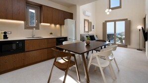 Eine moderne Küche mit Holzausstattung, einem eingebauten Geschirrspüler und einem Essbereich mit Tisch und Stühlen.