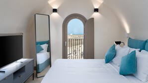 Ein Schlafzimmer mit Bett, Fernseher, Spiegel und einem Balkon mit Blick.