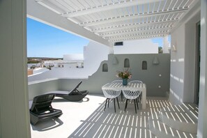 A balcony with a white pergola, a grill, and a table with chairs. - Villa Ioneira, Sea Views, Outdoor Hot Tub, Furnished Terrace, Santorini (Santorini)