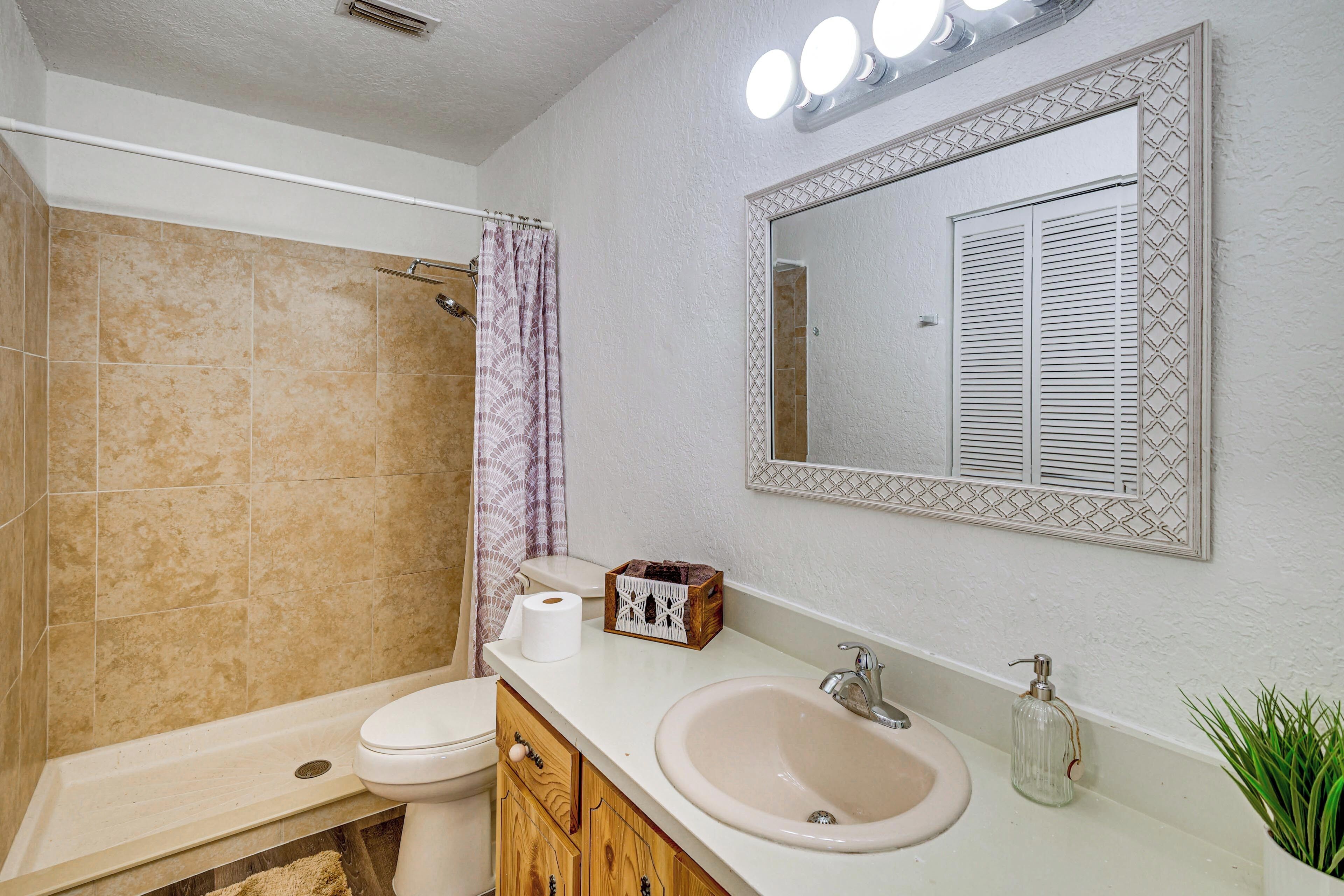 Une salle de bain avec des toilettes, un lavabo et une douche.