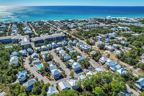 An aerial view of a coastal residential area with houses, roads, and a large building with a swimming pool. - Steps to 30A Beaches! 4BR Coastal Home - Sleeps 12 (Santa Rosa Beach)
