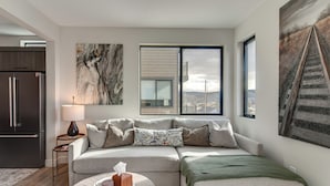 Ein modernes Wohnzimmer mit Ecksofa, Couchtisch und Bildern an den Wänden.