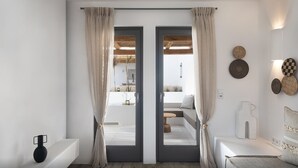 Una habitació moderna amb un finestral gran, un sofà i una taula petita.
