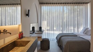 A modern hotel room with a large mirror, a stone sink, a small stool, two beds with checkered bedding, and sheer curtains. - Villa Averia, 2BDR, Private Heated Pool, Furnished Terrace, Lefkada (Lefkada)