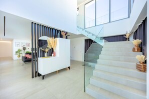 Ein modernes Interieur mit Treppe, einer weißen Rezeption und einem Glastrennband.