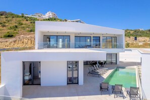 A modern two-story building with a rooftop pool, glass railings, and a view of the surrounding landscape. - Villa Vista Albufeira | Sea Views | Heated Pool | Walk to Marina (Albufeira)