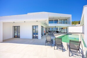 A modern outdoor pool area with lounge chairs and a clear blue sky. - Villa Vista Albufeira | Sea Views | Heated Pool | Walk to Marina (Albufeira)