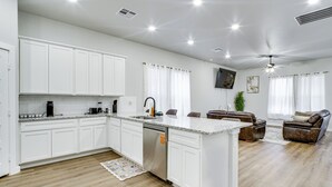 A modern kitchen with white cabinets, a built-in dishwasher, and a large island. - 8 Mi to Ttu! Pet-friendly Home w/ Patio & Yard (Lubbock)