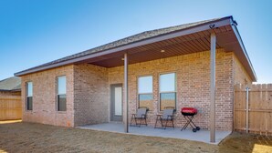 A single-story brick house with a covered patio, two windows, and a door. - 8 Mi to Ttu! Pet-friendly Home w/ Patio & Yard (Lubbock)