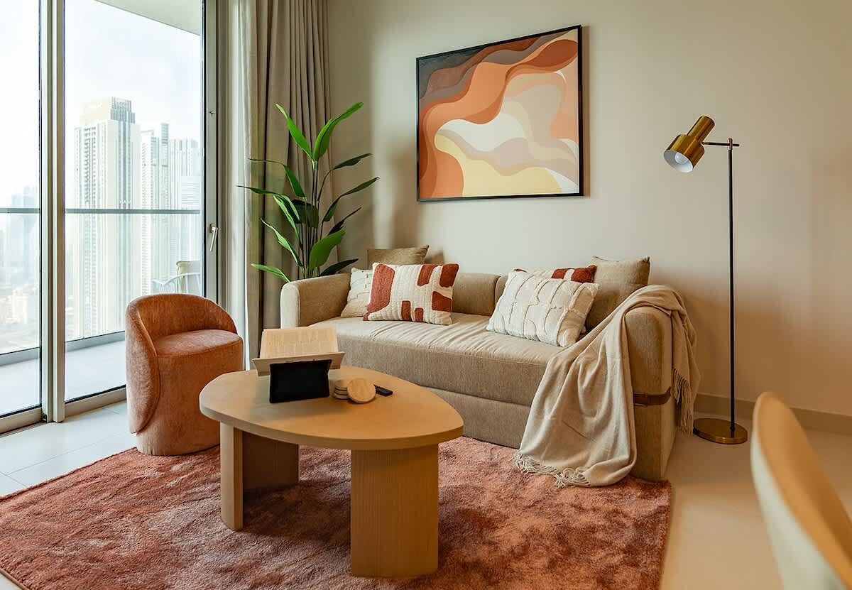 Un salon moderne comprenant un canapé, un fauteuil, une table basse et un lampadaire.
