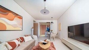 A modern living room with a sofa, coffee table, and a flat-screen TV. - Dubai Mall Apt w/ Burj Khalifa & Fountain Views (Dubai)