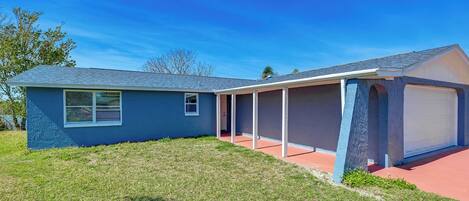 A single-story house with a garage, a covered porch, and a well-maintained lawn.