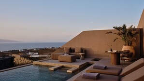 A rooftop pool area with lounge chairs and a view of the sea. - Rhethis Suite, Divine Sea Views, Infinity Pool, Oia (Santorini)