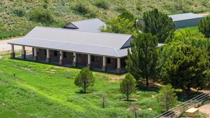 A building with a covered patio and a flat roof, surrounded by greenery and trees. - Peaceful, Serene Getaway 17 Mi to Dtwn Roswell! (Roswell)