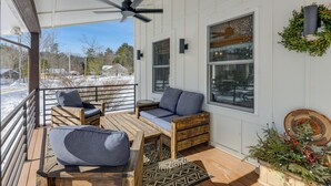 Un espace extérieur abrité, avec des meubles en bois et un ventilateur de plafond.