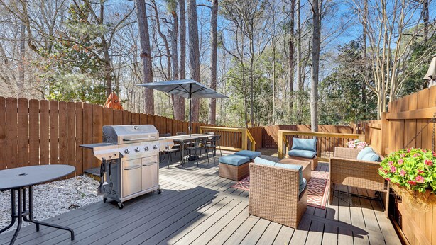 A wooden deck with a grill, dining table, and wicker furniture. - Great for Families! Quiet Auburn Getaway w/ Deck (Auburn)