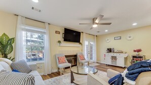 A living room with a fireplace, a flat-screen TV, and a coffee station. - Great for Families! Quiet Auburn Getaway w/ Deck (Auburn)